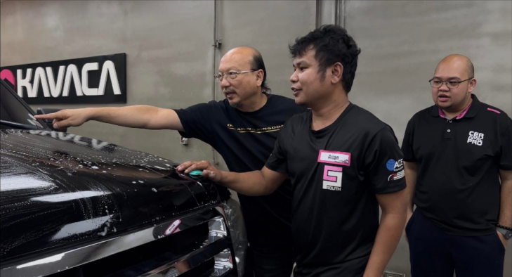 Mr. ジェシーが実車の前で指を差し、参加者に説明している様子